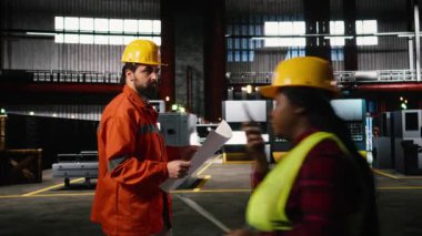 Mühendis tesiste yürüyor. Üretim planlarını, teknik planlarını, ağır sanayi deposunu inceliyor. Üretim salonu makine talimatları, düzen çizimleri içerir.