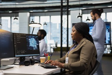 Engineer in office trains machine learning models for anomaly detection automation. Computer scientist utilizing artificial intelligence to optimize performance monitoring for immediate issue response