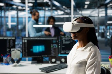 Veri merkezindeki sanal gerçeklik teknolojisini kullanarak sunucu raflarını yapay zekayla yükselten bir mühendis. VR kulaklık takan sunucu odası çalışanı yapay zeka kullanarak güncelleme ekipmanı kullanıyor.