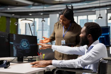 Belden aşağısı felçli işçilerin AI 'ı arızaları gidermek için kullandıkları işleri denetleyen müdür. Tekerlekli sandalyedeki programcıyı denetleyen takım lideri optimizasyon için yapay zeka kullanıyor.