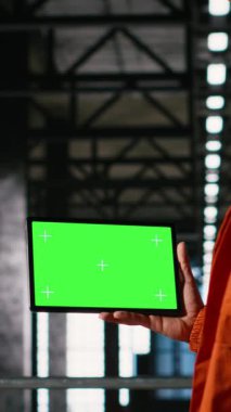 Dikey Video Chroma anahtar tableti, sert şapkalı mühendis, ağır sanayi, üretim hattı, endüstriyel mühendislik fabrikasında çelik işi sağlama. Fabrikadaki makinelerle üretim süreci.