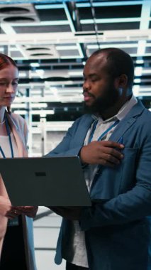 Dikey video sunucusu çiftlik yöneticisi indüksiyon sırasında interne dizüstü bilgisayar kullanmayı ve elektroniği optimize etmeyi öğretiyor. Veri Merkezi takım lideri ve stajyer sistem performansını izlemek için not defteri kullanıyor, kamera A