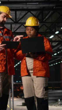 Dikey Görüntü Mühendisliği ekibi çelik işçiliği ve endüstriyel alandaki ağır ekipmanları inceliyor. Makine, demir fabrikası ve kaynakla büyük ölçekli üretim tesisinde ağır sanayi operasyonları.