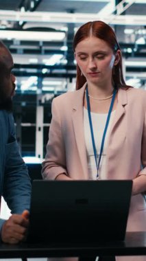 Güç tüketimini izlemek ve işbirliği yapmak için laptop kullanan dikey video sunucu merkez mühendisliği ekibi. Veri Merkezi iş arkadaşları beyin fırtınası yapıyor, donanımı denetliyor, endüstri standartlarına uymayı güvence altına alıyor