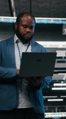 Elektronik, dizüstü bilgisayar ve yazılım geliştiricilerinin sunucu çiftliğinde optimize edildiği dikey video. Veri merkezi izleme sistemi performansında beyin fırtınası, not defteri ve takım çalışması meslektaşları