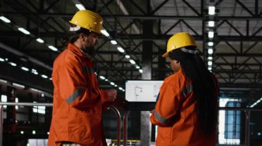 Çeşitli mühendisler, makine dairesinde özerk robot kolu olan montaj hattını destekleyen endüstriyel bileşenler için robot yazılımını analiz ederler. Çelik işçiliği olan büyük ölçekli bir depo..