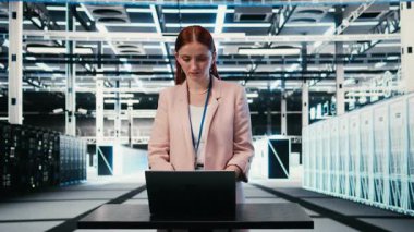 Güç tüketimi, laptop ve kadının sunucu merkezindeki çalışma masasında izlenmesi. Endüstri standartlarının uyum sağlamasını sağlayan veri merkezindeki ekipman, defter ve çalışanlar, kamera A