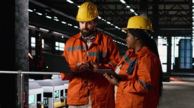 Üretim hattına çeşitli mühendisler, ağır ekipmanları izleme, büyük ölçekli fabrika, sanayi takım çalışması, makine salonu ve metalik çerçeve hakim, mühendislik tesisi.