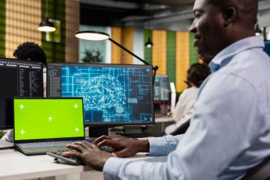 Yapay zeka teknolojisi şirketinin işyerindeki geliştiriciler tarafından kod incelemeleri yapmak için kullanılan krom anahtar laptop. Makine öğrenme algoritmaları tasarlamak ve uygulamak için ofis masasında maket defteri kullanan bilişim uzmanı