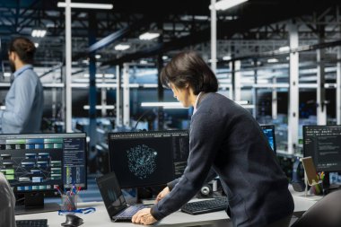 Sunucu odasındaki yazılım geliştiricisi altyapı teşhislerini incelemek için aygıt kullanıyor. Yüksek teknoloji veri merkezindeki adam sistem uptime 'ı korumak için performans verilerini analiz ediyor