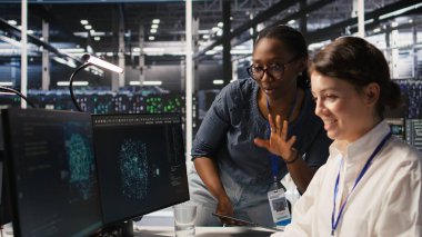 Neşeli veri merkezi mühendisleri başarılı yapay zeka sistemi konuşlandırmasını tamamladıktan sonra yumruk tokuşturuyorlar. Gülümseyen iş arkadaşları optimal makine öğrenme modeli performansının ardından kutlama yapıyorlar, kamera A