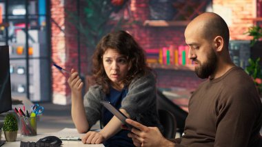 Girişimci işçiler iş konferansını PC monitöründen izliyor, deftere bilgi yazıyor ve görüşlerini paylaşıyorlar. Çalışanlar bilgisayardaki sunum grafiklerine bakıyor, not alıyorlar. Kamera B.