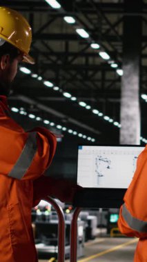 Dikey video mühendisleri, robot kolu performansı, dizüstü bilgisayar robotları, mühendislik fabrikası. Montaj hattı için kullanılan otonom araçları denetleyen işçiler, büyük ölçekli elektronik donanım