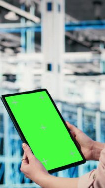 Sunucu merkezi yönetimi tarafından güç tüketimini izlemek için kullanılan dikey video izole edilmiş ekran tableti. Veri merkezi bilişim uzmanı krom anahtar cihazlı ekipmanları denetleyerek endüstri standartlarını güvence altına alıyor