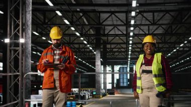 Bir fabrikada ağır sanayi operasyonlarını izleyen kadın mühendis, demir fabrikası ve endüstriyel tasarımı olan geniş bir mühendislik fabrikası. Makine dairesi. Ağır ekipmanlarla dolu büyük bir depo..