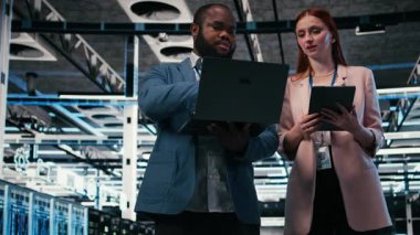 Sunucu odası takım arkadaşları işlevsel etkinliği arttırmak için tablet ve dizüstü bilgisayar kullanıyor. Mühendislik ekibi veri merkezinde beyin fırtınası yapıyor, ekipman çantalarını, kamera A 'yı izlemek için cihazlar kullanıyor.