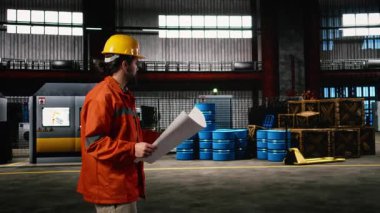 Adam mühendis, planlar, çizimler, planlar, makine dairesi. Metal işçiliği, ağır ekipman ve üretim sürecine rehberlik eden ileri teknolojiyle dolu sanayi bölgesi.