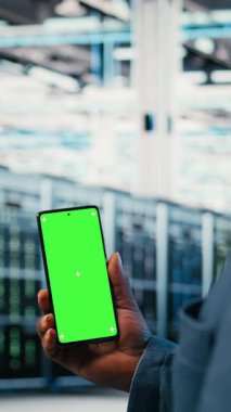 Sunucu odasındaki çalışanlar tarafından elektronik aletleri izlemek için kullanılan dikey Chroma tuşlu akıllı telefon. Sistem yöneticisi tarafından BT çözümlerini işleten kurumsal bulut hesaplamasını yönetmek için kullanılan izole ekran cep telefonu