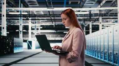 Elektronik, dizüstü bilgisayar ve kadın sunucu çiftliğinde iyileştirmeler yapıyor. İzleme sistemi performansı, not defteri ve veri merkezinde yürüyen kadın teknisyen, darboğazları tanımlıyor, kamera A