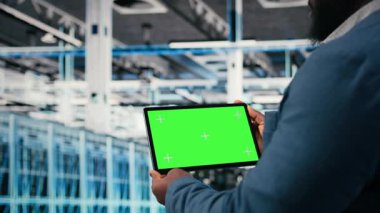 Bilgi Merkezi çalışanı tarafından bilgisayar kullanarak bilişim çözümlerini hesaplayan bir girişimi yönetmek için kullanılan yeşil ekran tableti. Fütürist sunucu çiftliği, kamera A 'yı izlemek için dokunmatik ekran aygıtı kullanan yönetici