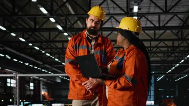 Çeşitli mühendisler, telsiz, taşınabilir alıcı-verici, ağır sanayi santrali, kaynak istasyonları ve büyük ölçekli makine salonundaki dizüstü bilgisayarla yapılan çelik işleri denetliyorlar. Üretim süreci.