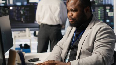 Veri merkezindeki stresli teknisyen yapay zeka sunucusu altyapısını yönetiyor, kahve içiyor. Yapay zekayı çalıştırmak için bilgisayar kullanan Afro-Amerikan işçiler, son teslim tarihiyle panikledi, kamera A