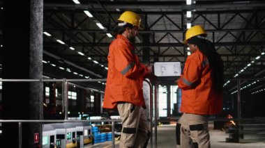 Çok ırklı mühendisler, robot kolu performansı, dizüstü bilgisayar robotları, mühendislik fabrikası. Montaj hattı için kullanılan otonom araçları denetleyen işçiler, büyük ölçekli üretim için elektronik donanım.