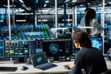 Sunucu çiftliği bilişim uzmanı otomatik iş akışlarını otomatik hale getirmek için makine öğrenme araçları kullanıyor. AI eğitim prosedürlerinde görevleri düzene sokmak için kullanılan büyük veri tabanlarını yöneten veri merkezi sistem yöneticisiName