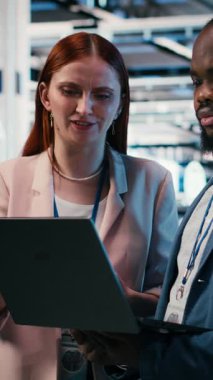 Elektroniği optimize eden dikey video sunucu çiftliğinde indüksiyon sırasında intörn öğreten dizüstü bilgisayar ve yönetici. Sistem performansı, not defteri ve veri merkezinde staj yapan takım lideri, kamera B