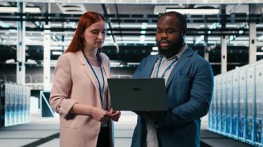 Sunucu çiftlik müdürü indüksiyon sırasında intörnlere dizüstü bilgisayar kullanmayı ve elektroniği optimize etmeyi öğretiyor. Veri merkezi takım lideri ve stajyer sistem performansını izlemek için not defteri kullanıyor, kamera B