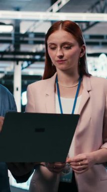 Sunucu merkezinde bakım, dizüstü bilgisayar ve mühendislik yapan dikey video işleri bitirmek için birlikte çalışıyor. Modern yüksek teknoloji veri merkezindeki ayarlar, sunucular ve takım çalışması meslektaşları yapılandırılıyor