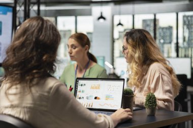 İş dünyasının rekabetçi sektöründe bir strateji oluşturmak için performans veri analizini kullanan ofis çalışanları takımı, verimli planlama yoluyla proje hedeflerini hızlandırmak için yetkilendirilmiş kadınlar.