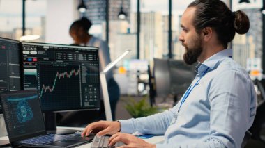 Ofisteki portföy yöneticisi, ekonomik grafiklere dayalı sermaye tahsisini değerlendirmek için dizüstü bilgisayardaki yapay zeka yazılımını kullanıyor. Gündüz işlemcisi, araştırma yapmak için defter üzerinde derin öğrenme kullanıyor.