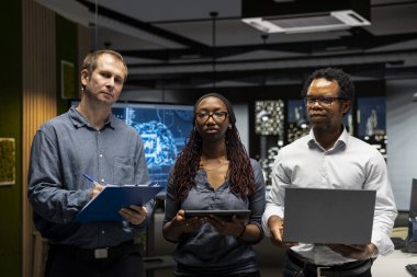 Yapay zeka otomasyonunu kullanarak uygulamaları geliştiren teknoloji firmasındaki programcıların portresi. Cihazlar üzerinde çalışan bilişim uzmanlarından oluşan bir ekip, yapay zekayla uygulamaları hata ayıklıyor