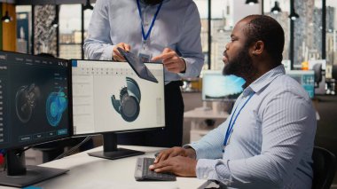 Rüzgâr türbini tasarımını optimize etmek için CAD uygulamasını kullanarak karbon ayak izini azaltan bir mühendis yöneticisi. Ar-Ge ekip lideri ve işçi, çevre dostu yel değirmeni parçaları için gelişmiş materyalleri test ediyor.