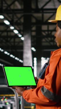 Dikey video izole tablet, kroma anahtar ekranı, Afro-Amerikan mühendisi, ağır sanayi deposu, büyük ölçekli metal işleme istasyonları ile büyük üretim ve imalat istasyonları