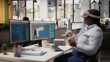 Alternatif enerji teknolojisi kullanarak güneş enerjili cihaz tasarımı yapmak için VR kulaklık kullanan bir teknisyen. İşçi çevre dostu güneş cihazları geliştirmek için sanal gerçeklik simülasyonu kullanır, kamera A