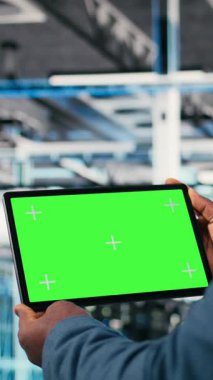 Veritabanı çalışanı tarafından kullanılan dikey video yeşil ekran tableti bilgisayarlı bilişim çözümlerini yönetmek için dizüstü bilgisayar kullanıyor. Gelecekteki sunucu çiftliğini izlemek için dokunmatik dokunmatik ekran aygıtı kullanan yönetici