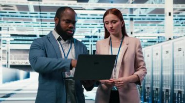 Sunucu merkezindeki mühendislik ekibi bilgisayarlarla birlikte çalışarak makinelerin bakım işlerini hallediyor. Modern yüksek teknoloji veri merkezinde çalışan takım arkadaşları sunucu ayarları, kamera B