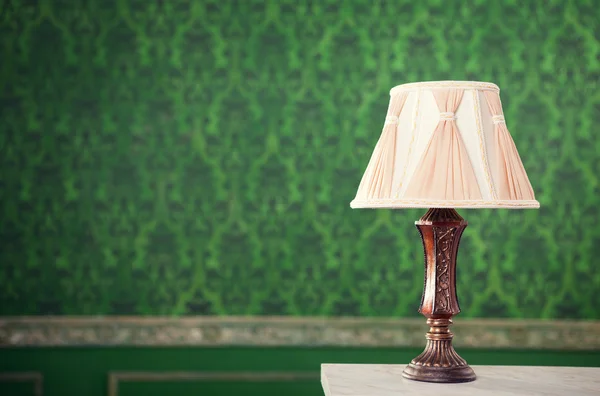 Vintage lamp on fireplace on retro pattern background — Stock Photo, Image
