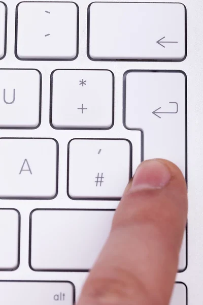 Finger pressing on enter key on keyboard — Stock Photo, Image