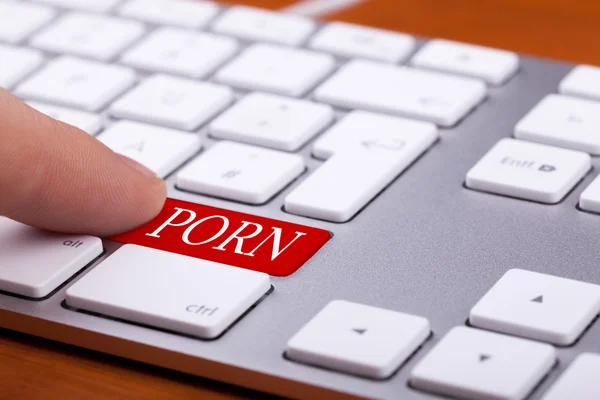 Finger drückt auf roten Knopf mit Pornowort drauf — Stockfoto