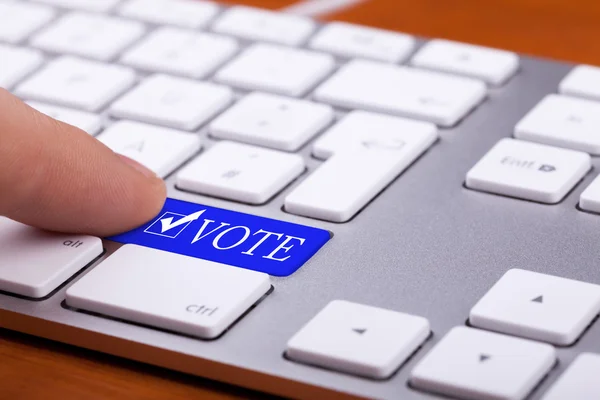 Dedo pressionando voto botão azul e símbolo — Fotografia de Stock