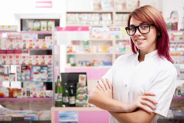 Smiling young doctor with eyeglasses in front of working desk — Stock Photo, Image