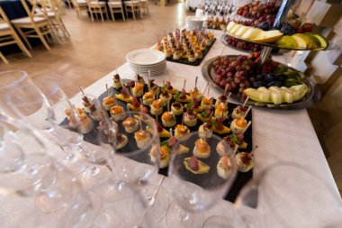 Konuklar için ziyafet masasında meyveli soğuk kanepeler ve aperatifler ana yemekten önce bir aperatif.