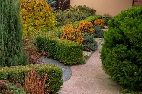 ランドスケープデザインの花壇には常緑樹や季節の植栽や低木が家の領土を飾る — ストック写真