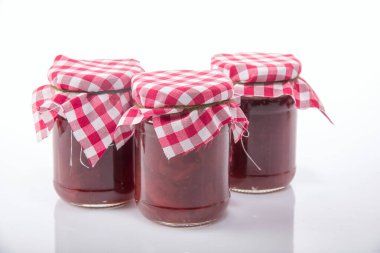 Beyaz arka planda kumaş kapaklı kavanozlarda reçel
