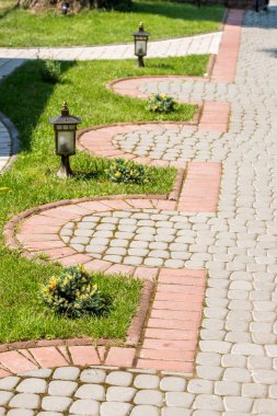 Yol taşlarla ve dekore edilmiş sokak lambalarıyla dolu.