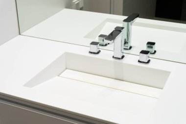 Banyodaki lavaboda krom musluklar.