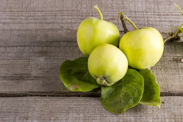 Jabłka z liści na stole w ogrodzie — Zdjęcie stockowe
